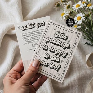 May include: Two cream-colored cards with black text are held in a hand. One card reads "Thank You!" in a retro font. The other card says "This package is happy to see you too!" with star accents. A bouquet of daisies is in the background.