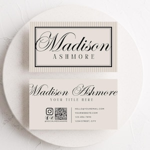 Pu&ograve; includere: Due biglietti da visita con il nome "Madison Ashmore" in elegante scrittura. La carta superiore ha uno sfondo a righe e quella inferiore include icone di social media, un codice QR e informazioni di contatto. Le carte sono beige chiaro.