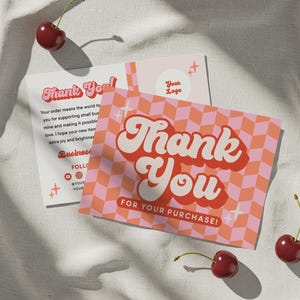 May include: Two retro-style "Thank You" cards with a pink and orange checkered pattern and the text "Thank You For Your Purchase!". The cards are accompanied by fresh cherries on a white surface.