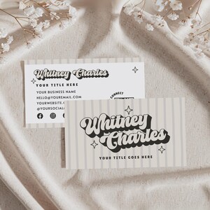 May include: Two business cards featuring the text "Whitney Charles" in a retro font. One card has vertical stripes and the other has the business name, title, email, website, and social media handles. The cards are light beige and white.