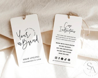 Puede incluir: Dos etiquetas rectangulares blancas con texto negro. La etiqueta de la izquierda tiene el texto "Your Brand" con un símbolo de corazón. La etiqueta de la derecha tiene el texto "Care Instructions" e incluye instrucciones para lavar, secar y planchar. El texto también incluye iconos de redes sociales y el texto "@YOURSOCIALMEDIANAME".
