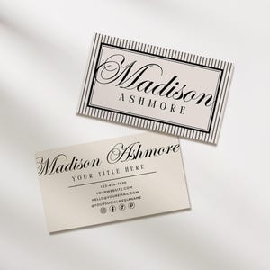 May include: Two business cards with the name "Madison Ashmore" printed in elegant script. The top card has a striped border. The bottom card includes contact information and social media icons. The cards are cream-colored.