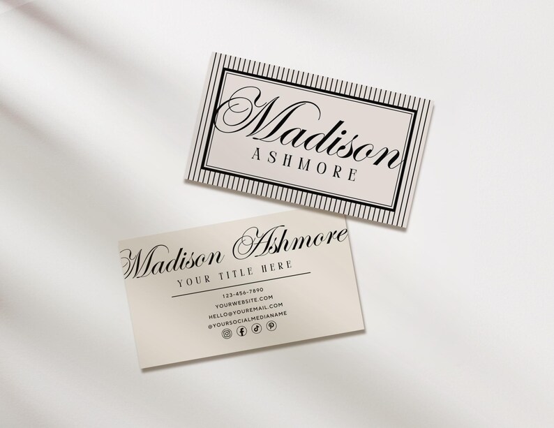 May include: Two business cards with the name "Madison Ashmore" printed in elegant script. The top card has a striped border. The bottom card includes contact information and social media icons. The cards are cream-colored.