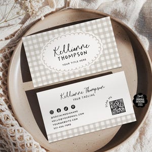 May include: Two business cards with a light gray gingham pattern. The top card has the name "Kellianne Thompson" in script within a scalloped oval. The bottom card includes social media icons, contact info, a QR code, and the text "Kellianne Thompson, YOUR TAGLINE".