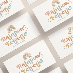 Puede incluir: Cinco tarjetas de visita blancas con un dise&ntilde;o de arco&iacute;ris y estrellas. El texto en las tarjetas dice "Rainbow Eclectic Baby Boutique".