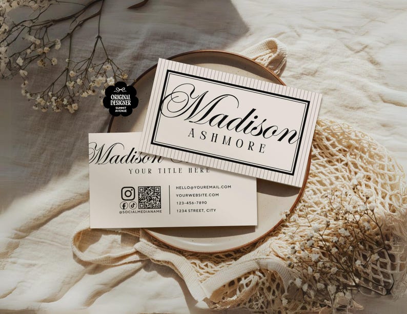 Pu&ograve; includere: Due biglietti da visita con il nome "Madison Ashmore" in elegante scrittura. Uno &egrave; sopra l'altro, con un bordo nero e uno sfondo a righe. Il biglietto inferiore include icone di social media e informazioni di contatto.