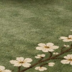 Puede incluir: Una alfombra verde con un dise&ntilde;o floral. La alfombra presenta un patr&oacute;n de flores blancas con centros amarillos y un tallo marr&oacute;n. El fondo es de color verde liso.