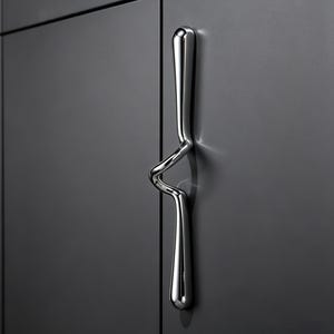 Könnte beinhalten: Ein polierter Chrom-Schrankgriff mit einem einzigartigen, geschwungenen Design. Der Griff ist an einer dunkelgrauen Schranktür befestigt und schafft eine moderne und minimalistische Ästhetik. Die Form des Griffs ist sowohl funktional als auch dekorativ.
