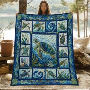 May include: A rectangular quilt featuring a large central sea turtle surrounded by smaller panels depicting sea turtles, ocean waves, seaweed, and seashells in various shades of blue and green with a decorative border of swirling patterns.