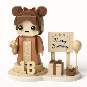 May include: A brown and beige Lego-style birthday figurine. The figurine features a girl holding a bouquet, with the number 18 at the base. A sign that says "Happy Birthday" is next to a gift box and a balloon.