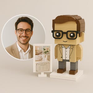 Könnte beinhalten: Eine Lego-Figur eines Mannes mit Brille und beigem Blazer, neben einem kleinen weißen Schild mit Hochzeitsbildern und Text. Ein Foto eines lächelnden Mannes mit Brille befindet sich in einem kreisförmigen Rahmen.