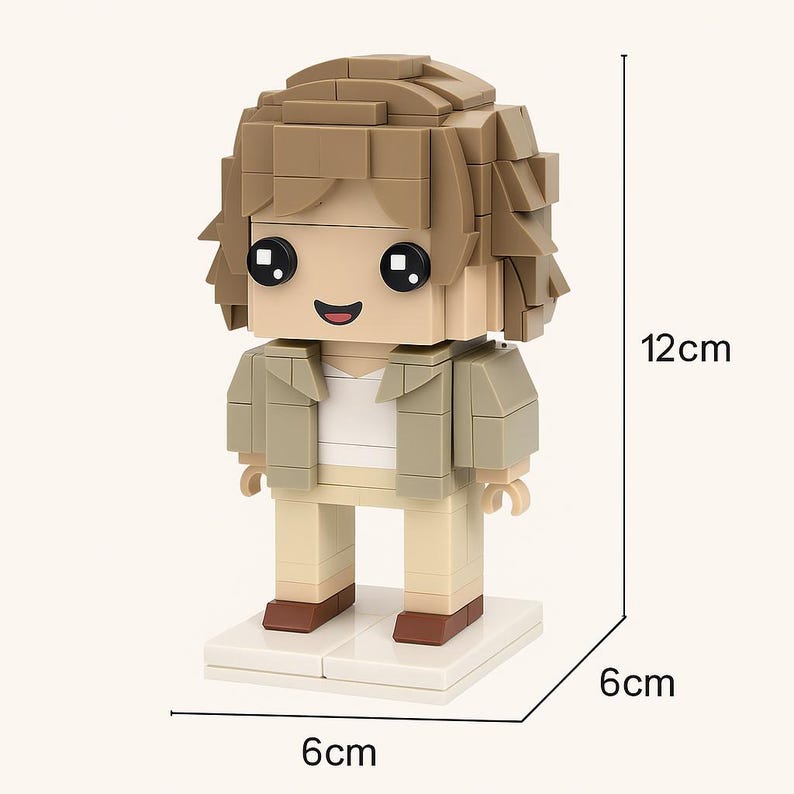 May include: A block figure toy, 12cm tall, with a tan jacket, white shirt, and beige pants. The figure has a blocky hairstyle and a smiling face with large black eyes. The base is 6cm x 6cm. The figure's shoes are brown.