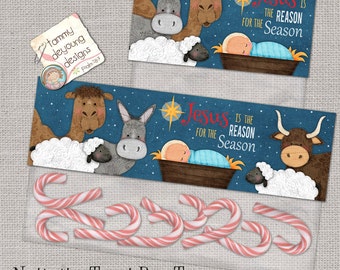 Puede incluir: Un topper para bolsa de golosinas de Navidad imprimible con un fondo azul y una escena de pesebre con un bebé Jesús, un burro, un camello y una vaca. El texto dice "Jesús es la razón de la temporada".