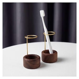 K&ouml;nnte beinhalten: Eine wei&szlig;e Keramik-Tasse mit schwarzem Henkel und dem Text "But First, Coffee" in schwarzer, fetter Schrift. Die Tasse steht auf einer wei&szlig;en Oberfl&auml;che.