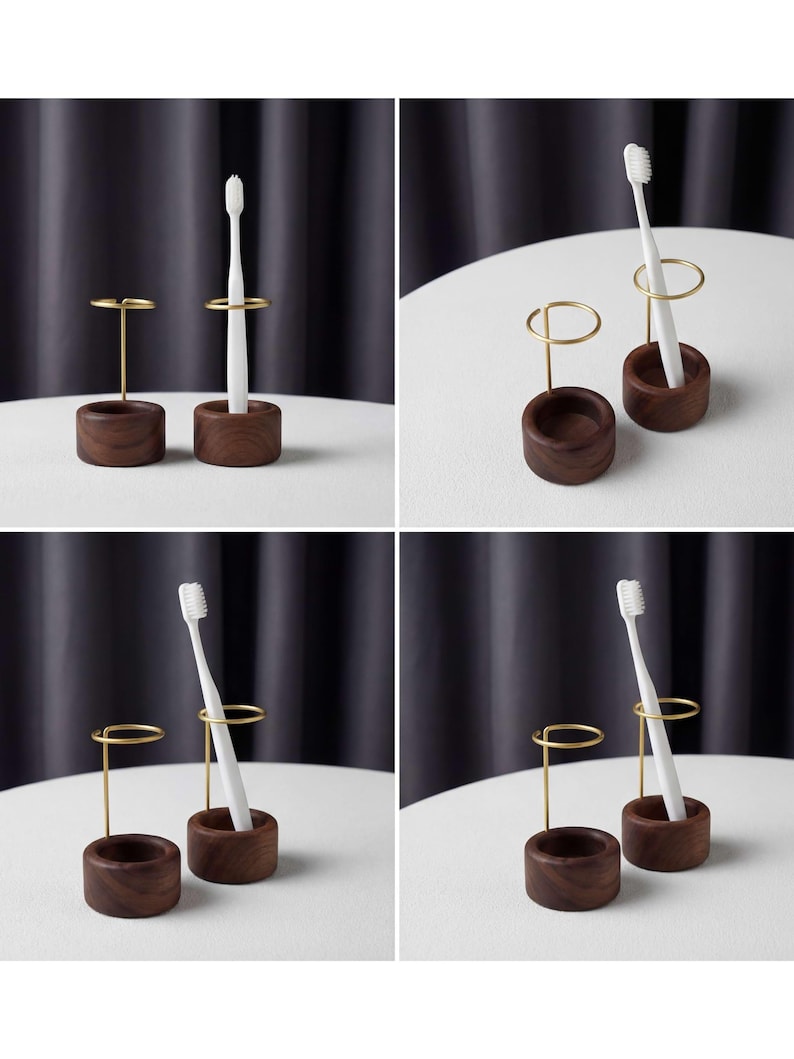 K&ouml;nnte beinhalten: Ein Set aus zwei Zahnb&uuml;rstenhaltern. Ein Halter ist ein kleiner, dunkelbrauner Holzzylinder mit einem goldfarbenen Metallring zur Aufnahme einer Zahnb&uuml;rste. Der andere ist ein passender Holzzylinder mit einem goldfarbenen Metallst&auml;nder.