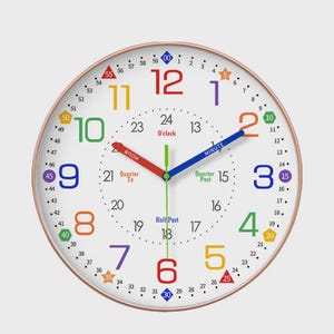 Può includere: Un orologio da parete rotondo e bianco con una cornice color oro rosa. Il quadrante dell'orologio presenta numeri e segni colorati per minuti e ore. La lancetta delle ore è rossa e la lancetta dei minuti è blu. L'orologio è progettato per scopi didattici.