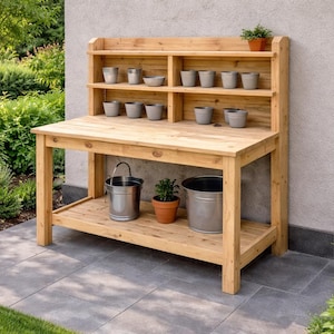 May include: A wooden potting bench with a shelf and a lower storage area. The bench is made of light-colored wood and has several small gray pots on the shelf. Two metal buckets and a terracotta pot are on the lower shelf.