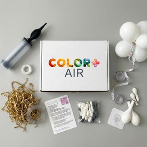 ColorPlusAir branded white gift box with rainbow logo surrounded by balloon kit components including hand pump, arch strip, glue dots, instruction card with QR code, ribbon, and white balloons. Premium DIY balloon garland and arch kit packaging. Complete balloon decoration kit for birthdays baby showers weddings shipped to USA UK and Canada.