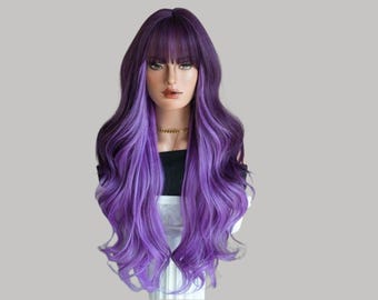 May include: A long, wavy wig with a dark purple base that fades into a lighter purple hue. The wig has a blunt fringe and is styled on a mannequin head. A gold necklace is visible.