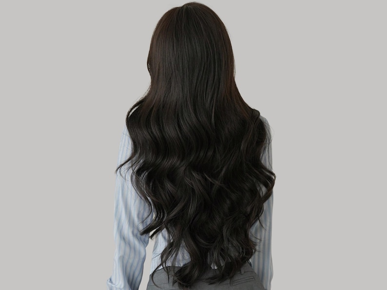 May include: Long, dark brown wavy hair cascading down the back. The hair is styled with loose waves and has a natural shine. The person is wearing a light blue striped shirt and gray pants.