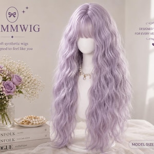 Op de afbeelding: Een lange, golvende, lichtpaarse synthetische pruik met pony op een wit etalagehoofd. De tekst NAMMWIG, Soft synthetic wigs designed to feel like you, DESIGNED WITH LOVE FOR EVERY VERSION OF YOU en MODEL SIZE: 34 INCH is zichtbaar.