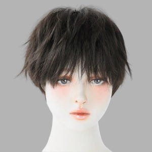 Puede incluir: Cabeza de maniquí con una peluca corta de color marrón oscuro. La peluca tiene un estilo en capas y texturizado con flequillo. El maniquí tiene una tez clara, con maquillaje sutil que incluye colorete y color de labios. El fondo es gris liso.