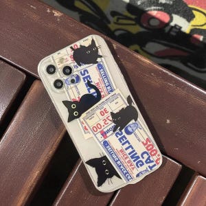 Może przedstawiać: Przezroczyste etui na telefon z ilustracjami czarnych kotów i grafiką w stylu vintage. Etui pozwala na prześwitywanie koloru telefonu. Bilety mają napis "SELLING BLACK NICE DVA".