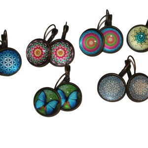 May include: Assortment of six pairs of earrings with various designs. The earrings feature a variety of colors and patterns, including blue, green, yellow, pink, and white. The earrings are made of metal and have a vintage look.