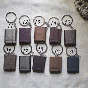 May include: Ten small leather keychains with silver rings and chains. The keychains are numbered 11 through 20.