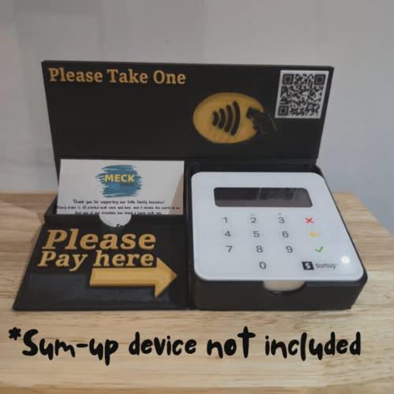 May include: Black point-of-sale display with the text "Please Take One" and "Please Pay here". Features a white payment terminal and a business card holder. The text "*Sum-up device not included" is at the bottom of the display.