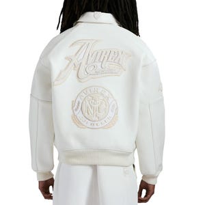 Puede incluir: Chaqueta bomber color crema con el logo Avirex New York bordado en la espalda. La chaqueta tiene cuello, pu&ntilde;os y dobladillo de canal&eacute;, y un parche circular debajo del logo. Dise&ntilde;o cl&aacute;sico y deportivo.