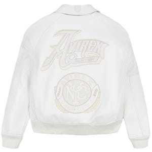 Puede incluir: Chaqueta de cuero blanca con el logo "Avirex New York" y un emblema circular en la espalda. La chaqueta tiene dobladillo y pu&ntilde;os de canal&eacute;, cuello y paneles perforados en las mangas.