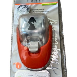 K&ouml;nnte beinhalten: Ein roter und transparenter Papier-Locher aus Kunststoff mit einem silbernen Hebel. Der Locher ist glockenf&ouml;rmig und tr&auml;gt ein Etikett mit der Aufschrift "Wedding Range Paper Punch". Der Locher befindet sich in einer transparenten Plastikverpackung.