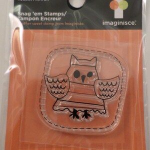 May include: Clear owl stamp from the Spooky Town Collection. The stamp features a cartoon owl design with a stitched border. The packaging includes the text "Snag 'em Stamps/Tampon Encreur" and the Imaginisce logo.