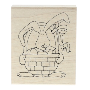 May include: A black and white line drawing of a bunny rabbit holding a basket full of Easter eggs. The bunny has a bow on its ear.