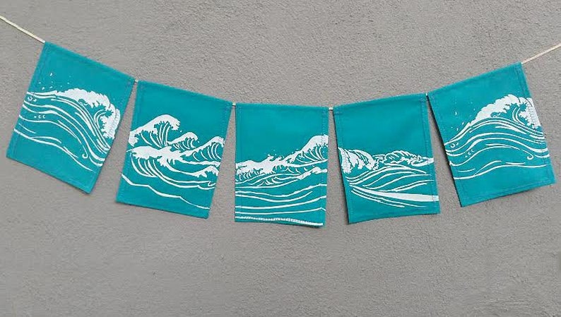 May include: A teal banner with five rectangular flags, each displaying a white wave design. The flags are strung together with a white cord, creating a decorative garland. The background is a solid gray.