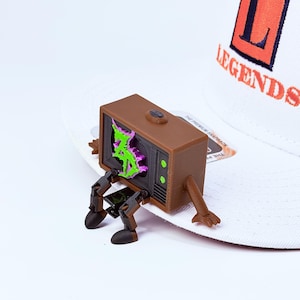 Zeds Dead TV buddy sitting on a white brim of a snapback hat