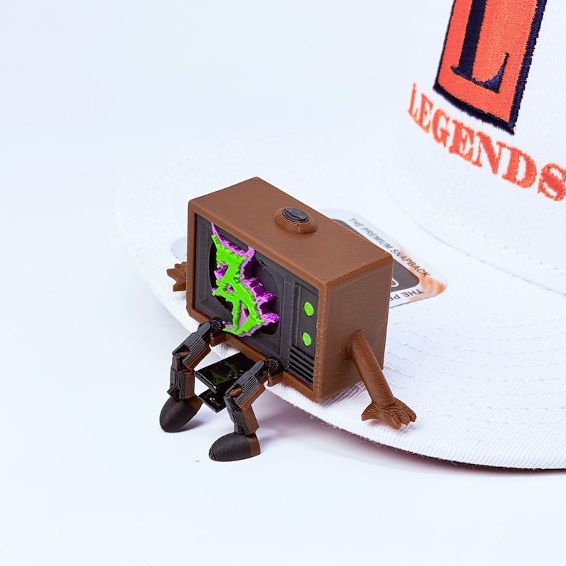 Zeds Dead TV buddy sitting on a white brim of a snapback hat
