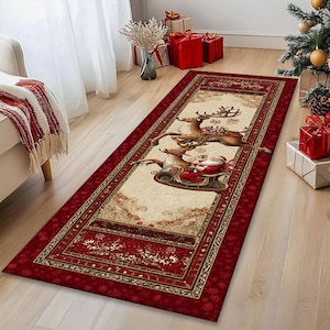 Op de afbeelding: Een rechthoekig kersttapijt met een rode rand en een cr&egrave;mekleurig middenstuk. Het middenstuk toont de kerstman in een slee getrokken door rendieren. Het tapijt heeft een decoratief bloemen- en sneeuwvlokkenpatroon.