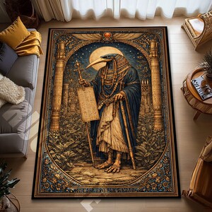 May include: A rectangular area rug featuring an Egyptian-themed illustration. The artwork depicts a bird-headed figure holding a staff and a scroll, set against a backdrop of columns, foliage, and a full moon. The rug has a detailed border with ornate patterns.