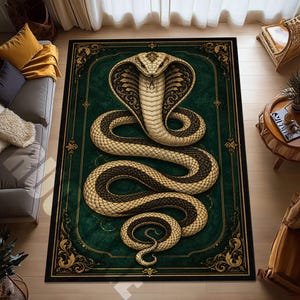 Può includere: Un tappeto rettangolare con una grande illustrazione centrale di un cobra color crema e nero con il cappuccio spiegato. Il tappeto presenta uno sfondo verde scuro racchiuso da un bordo nero con motivi in filigrana dorata agli angoli.