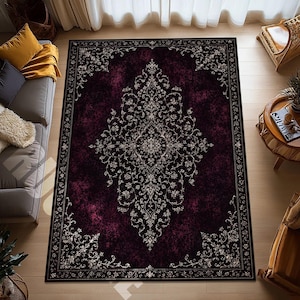 Puede incluir: Una alfombra rectangular con un fondo desgastado en color ciruela oscuro y negro, que presenta un gran medallón central intrincado y patrones florales ornamentados en crema y blanco, enmarcada por un borde negro fino.