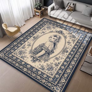 May include: A rectangular area rug with a cream-colored center featuring a portrait of a woman in a floral oval frame. The rug has a navy blue border with floral and geometric patterns.