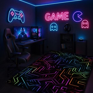 May include: A gaming room with neon lights. A neon blue controller and the word "GAME" in pink are on the wall. A black gaming chair sits in front of a desk with two monitors and a computer. A rug with a colorful circuit board design is on the floor.
