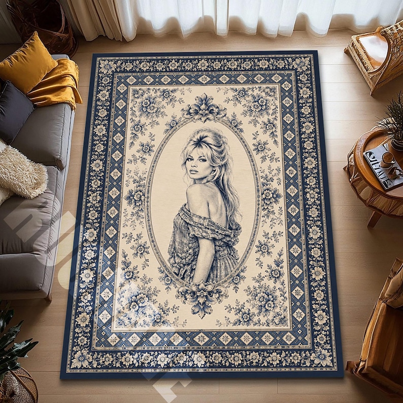 May include: A rectangular area rug with a navy blue border and a cream-colored center. The center features a portrait of a woman within an oval frame, surrounded by blue floral patterns. The rug's design incorporates a classic, vintage aesthetic.