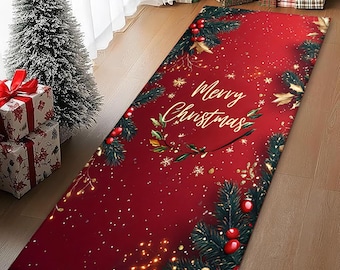 Op de afbeelding: Een rechthoekig rood kersttapijt met de woorden "Merry Christmas" in witte letters. Het tapijt is versierd met groene dennentakken, rode bessen en gouden accenten. Het tapijt ligt op een houten vloer.