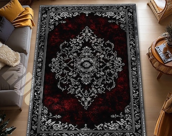 May include: A rectangular area rug with a dark red center and a black border. The rug features a detailed, ornate design in silver and white, with a central medallion and floral patterns. The rug is placed on a wooden floor.