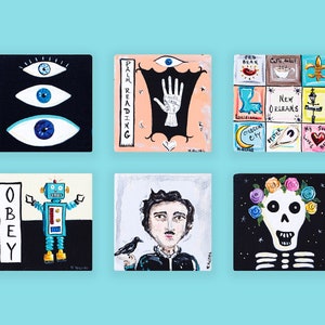 May include: Six square paintings with various designs. One features three blue eyes on a black background. Another shows a hand and the words "PALM READING". Other paintings depict a robot, a skull, and a portrait. The word "OBEY" is also visible.