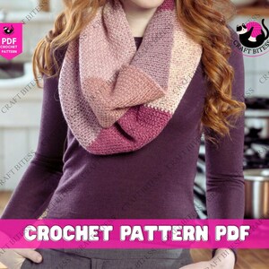 Op de afbeelding: Een gehaakte infinity sjaal in roze en crèmetinten. De sjaal is om de nek gewikkeld. De afbeelding bevat ook de tekst "CROCHET PATTERN PDF". De sjaal is ongeveer 150 cm lang.