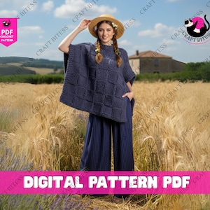 Op de afbeelding: Een vrouw draagt een marineblauwe gehaakte poncho met een vierkant patroon en een bijpassende broek met wijde pijpen. Ze draagt een strohoed en staat in een tarweveld. De afbeelding bevat de tekst "DIGITAL PATTERN PDF".